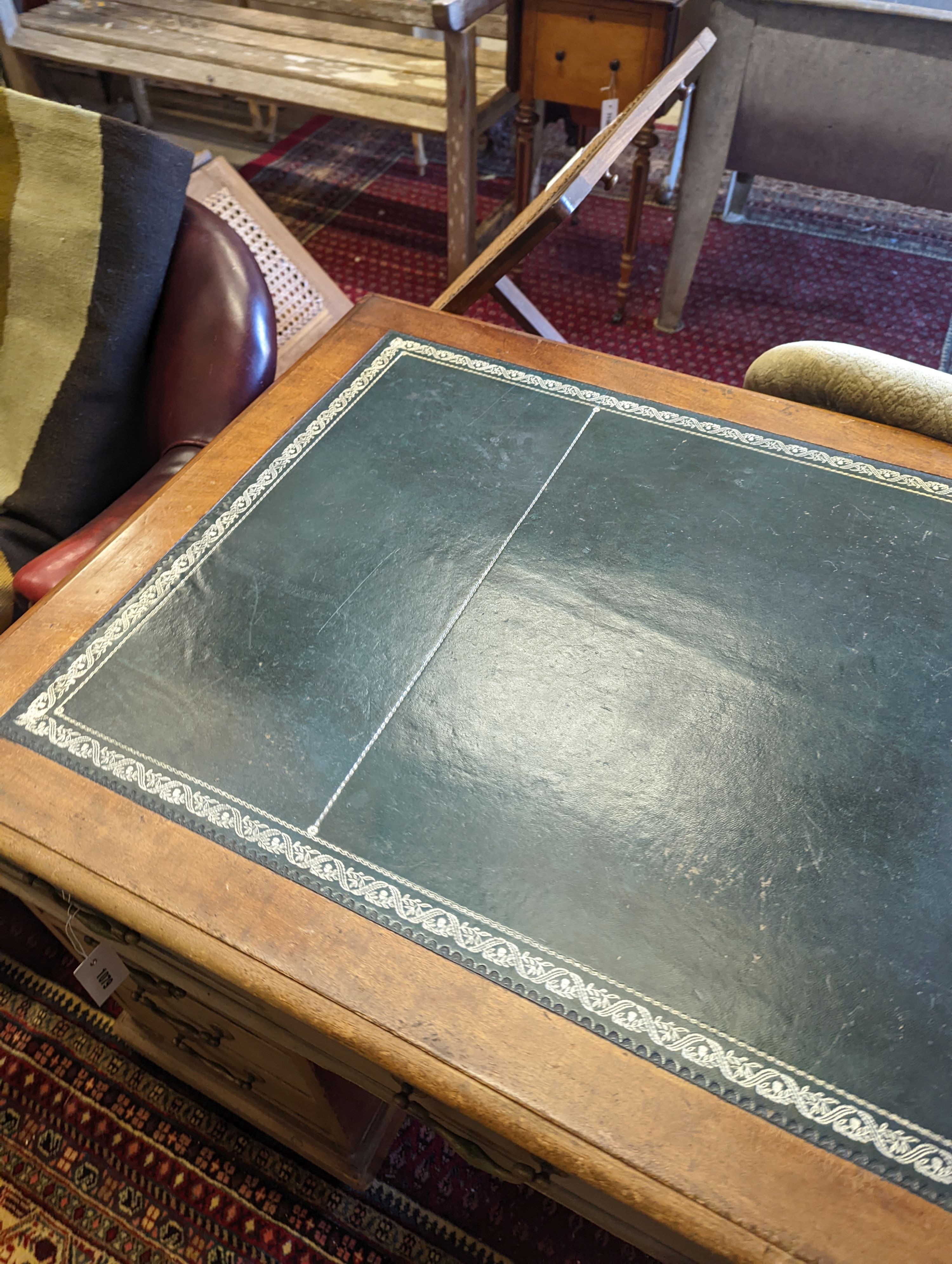 An Edwardian faded mahogany pedestal desk, stamped T. Willson, Great Queen Street, London, length 136cm, depth 76cm, height 76cm